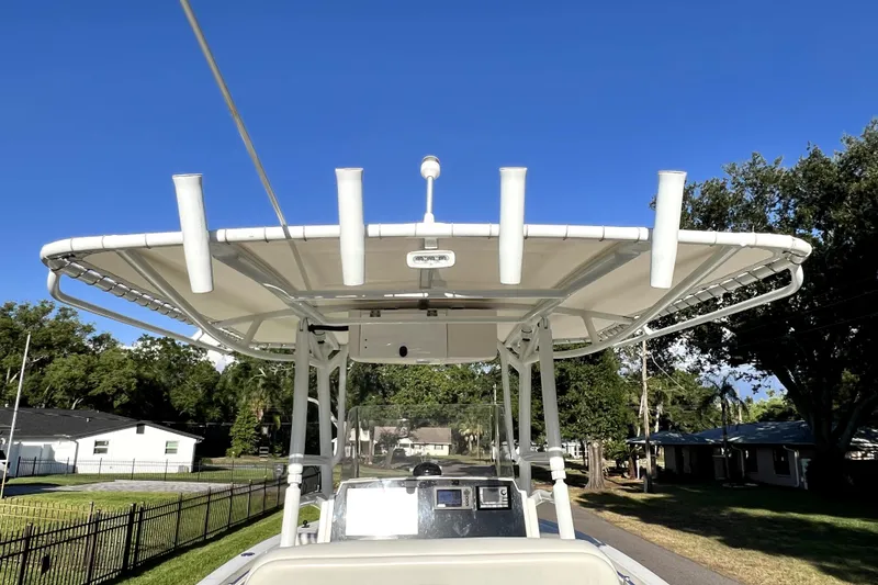 Slide: The Image of 2021 Cobia 240 Center Console boat with T-top and rod holders, parked on a sunny day. - 33