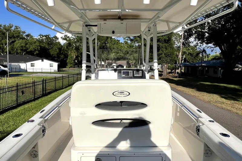 Slide: The Image of 2021 Cobia 240 Center Console boat with T-top, parked on a residential street. - 34