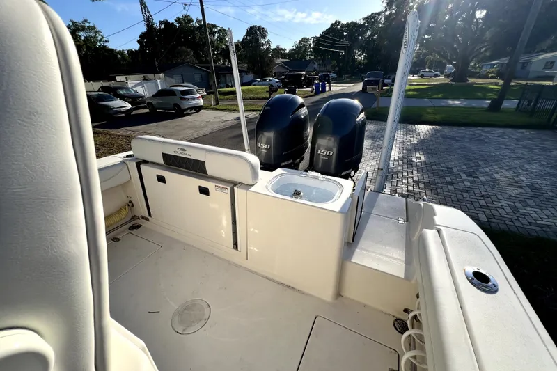Slide: The Image of 2021 Cobia 240 Center Console boat with dual 150 horsepower engines, parked in a driveway. - 39