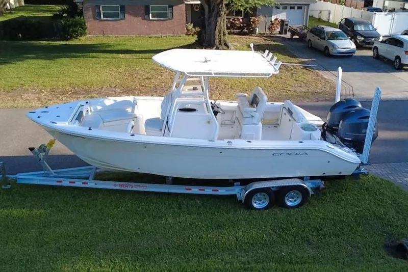 Slide: The Image of 2021 Cobia 240 Center Console boat on trailer, parked on grass. - 4
