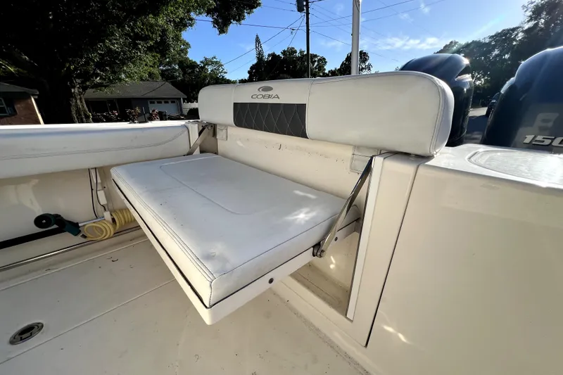 Slide: The Image of 2021 Cobia 240 Center Console boat with foldable white seat and dual engines. - 43