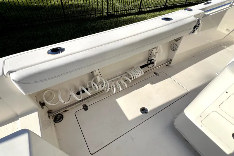 Slide: The Image of 2021 Cobia 240 Center Console boat interior with coiled hose and storage compartment. - 51