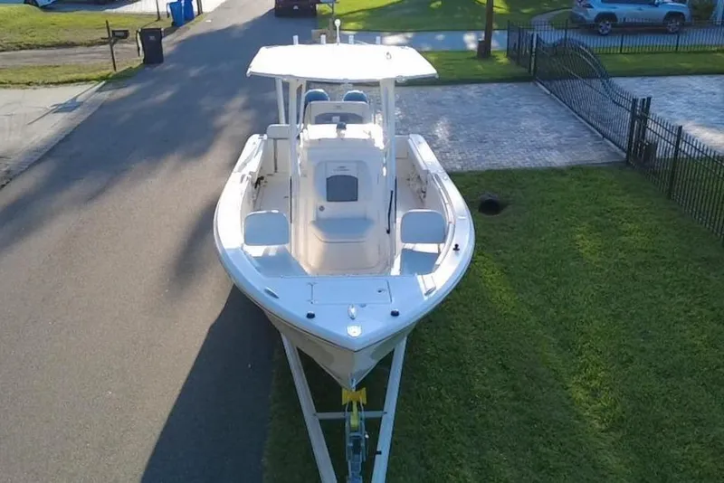 Slide: The Image of 2021 Cobia 240 Center Console boat on trailer in residential neighborhood. - 6