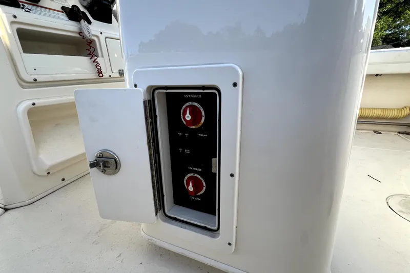 Slide: The Image of 2021 Cobia 240 Center Console boat's electrical panel with open access door. - 65