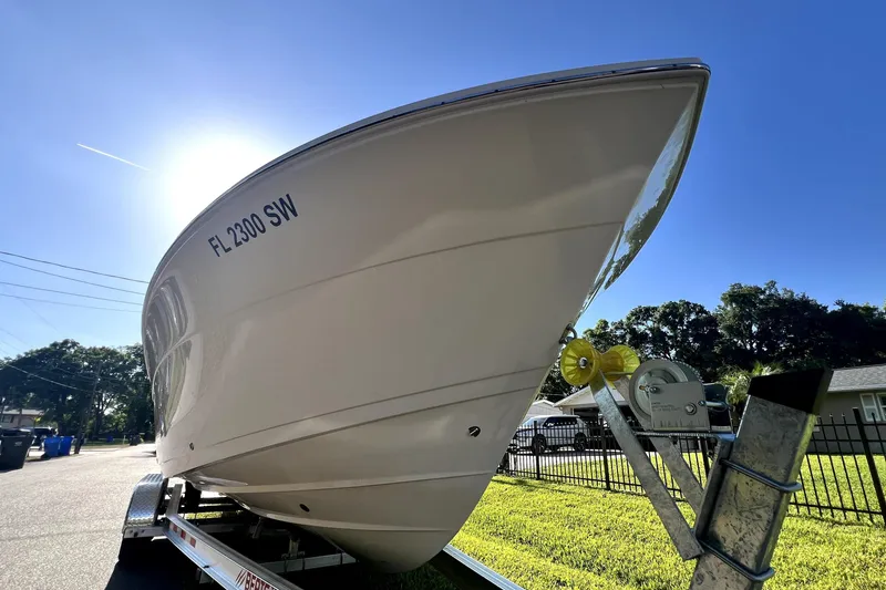 Slide: The Image of 2021 Cobia 240 Center Console boat on trailer under clear blue sky. - 7