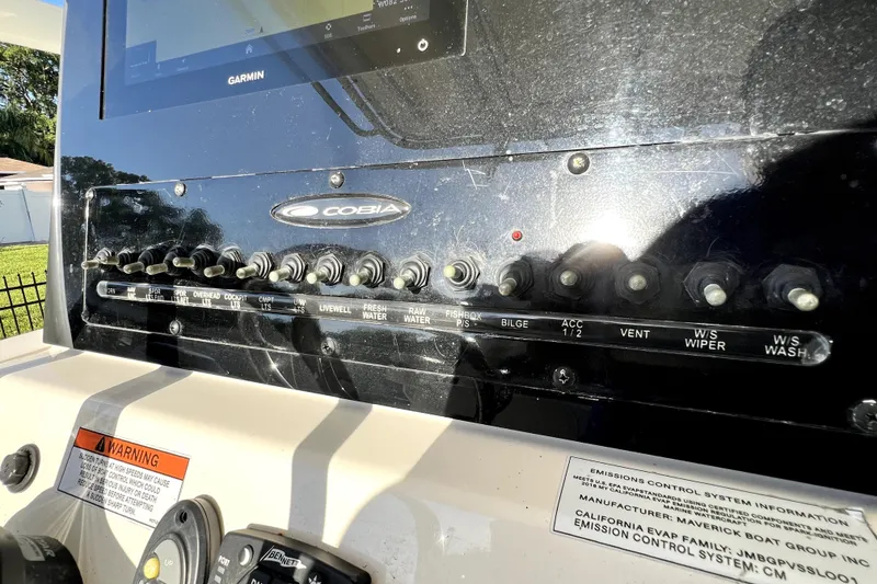 Slide: The Image of Control panel of a 2021 Cobia 240 Center Console boat with various switches and labels. - 75