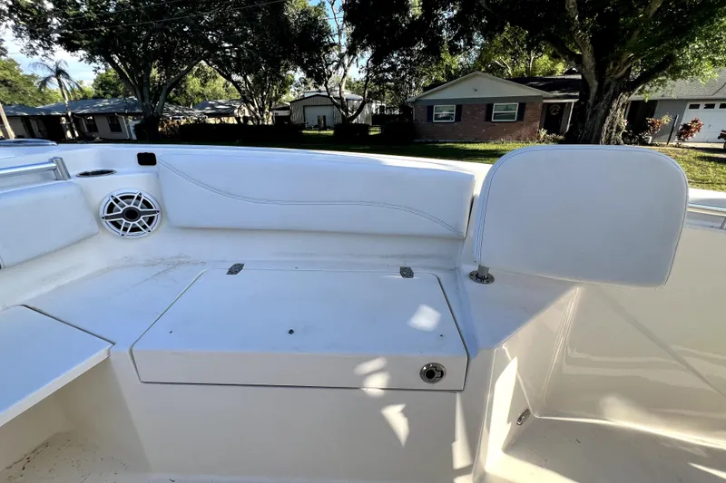 Slide: The Image of 2021 Cobia 240 Center Console boat interior with seating and speaker, parked in residential area. - 83