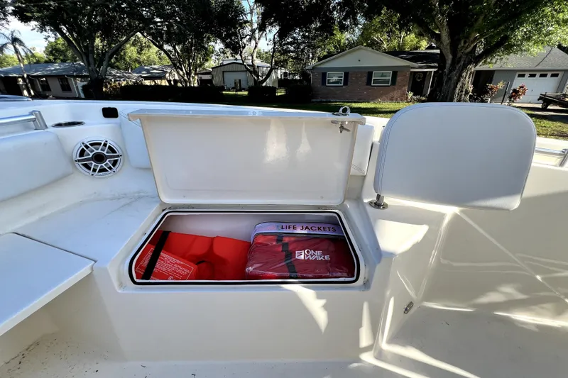 Slide: The Image of Open storage compartment on 2021 Cobia 240 Center Console with life jackets inside. - 84