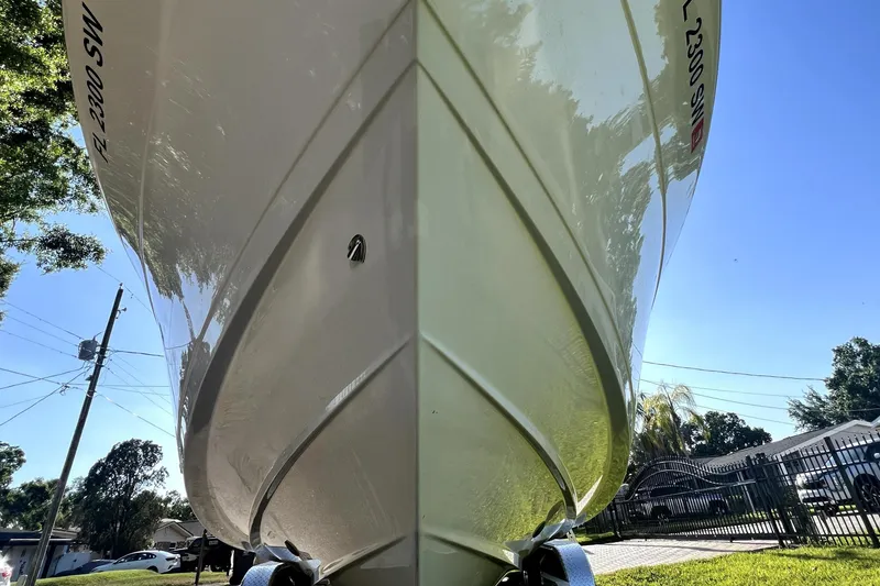 Slide: The Image of 2021 Cobia 240 Center Console boat on trailer, viewed from below, sunny day. - 9