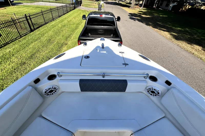 Slide: The Image of 2021 Cobia 240 Center Console boat on trailer, viewed from bow, parked on a residential street. - 92
