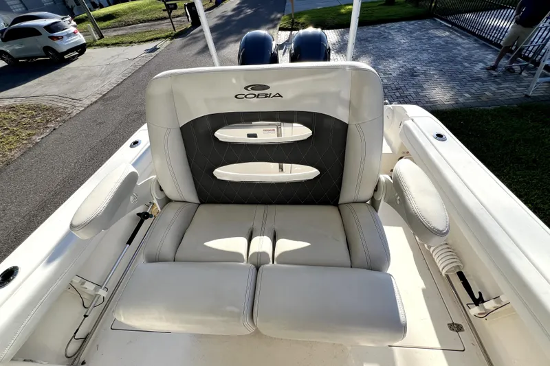 Slide: The Image of 2021 Cobia 240 Center Console boat seat with logo, featuring cushioned armrests. - 93