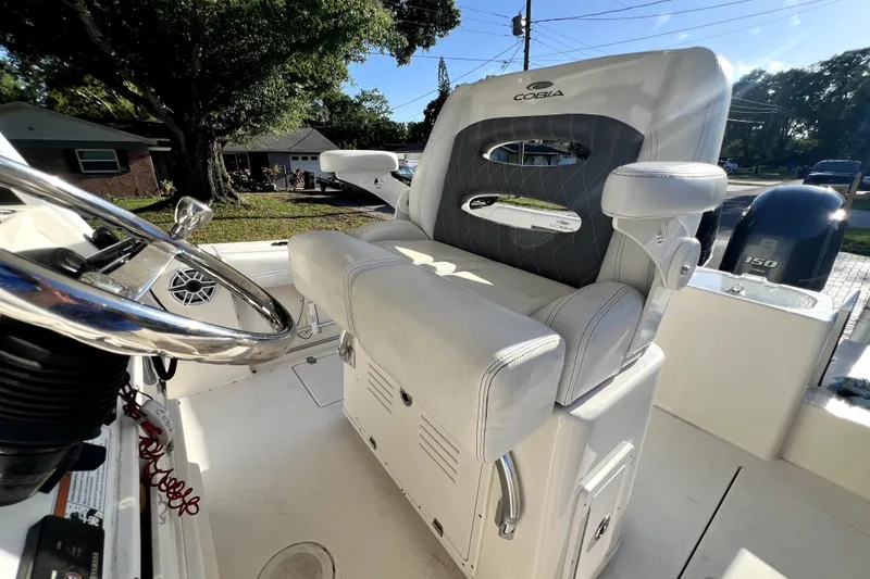 Slide: The Image of 2021 Cobia 240 Center Console boat interior with steering wheel and cushioned seat. - 94