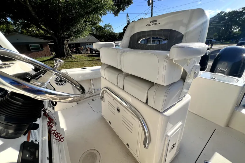 Slide: The Image of 2021 Cobia 240 Center Console boat interior with steering wheel and cushioned seating. - 95