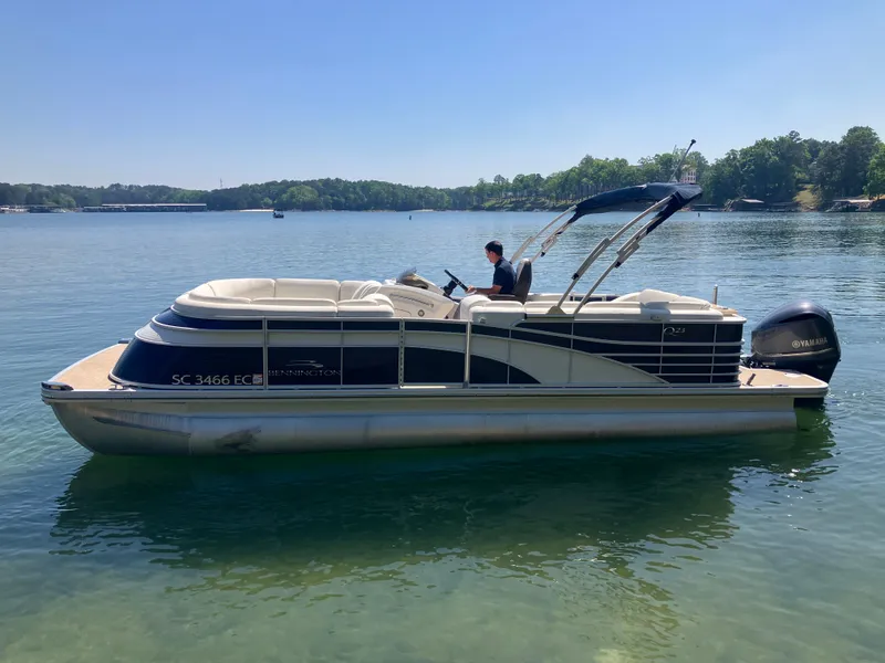 The Image of 2019 Bennington 23 QLC pontoon boat on calm lake. - 0