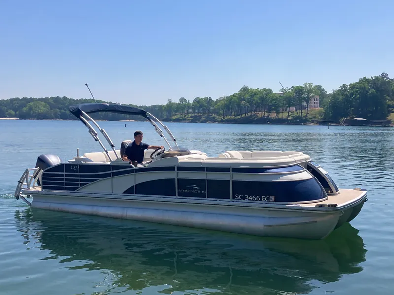 Slide: The Image of 2019 Bennington 23 QLC pontoon boat on a serene lake. - 3