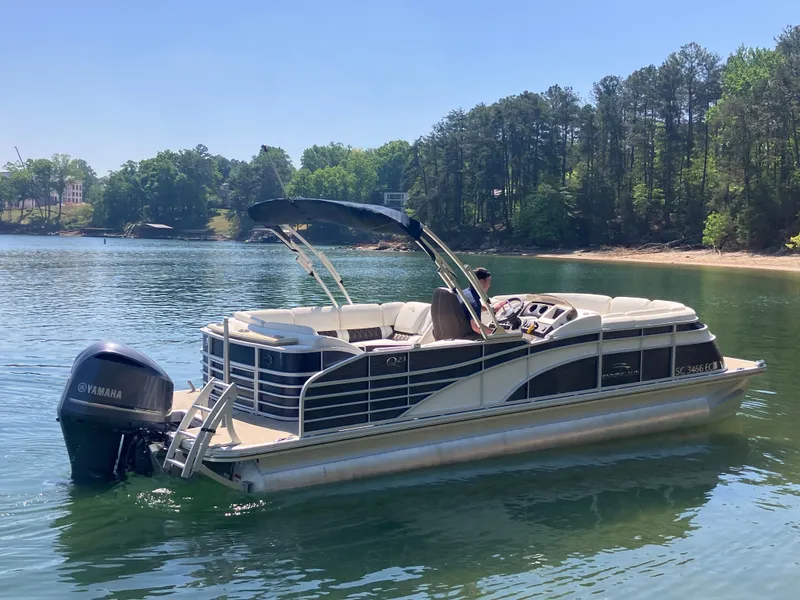 Slide: The Image of 2019 Bennington 23 QLC pontoon boat on a serene lake. - 5