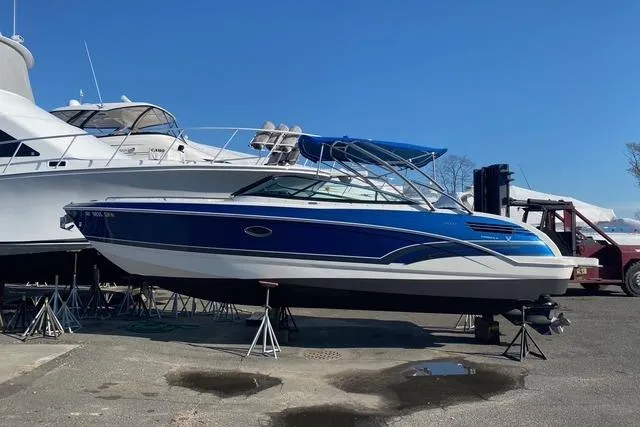 The Image of 2016 Formula 290 Bowrider boat in a marina, elevated on stands, with a blue hull. - 0