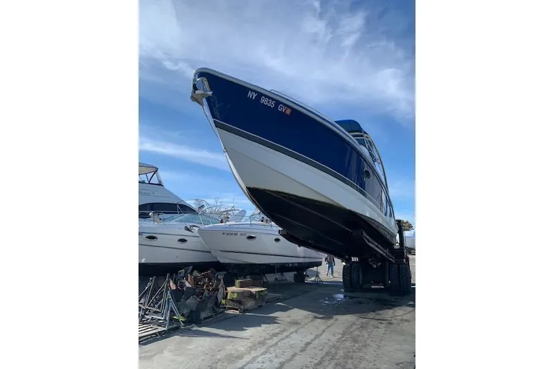 Slide: The Image of 2016 Formula 290 Bowrider boat on trailer, blue and white hull, parked outdoors. - 10