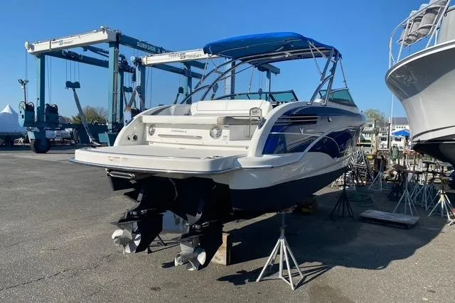 Slide: The Image of 2016 Formula 290 Bowrider boat on stands, blue canopy, marina setting. - 12