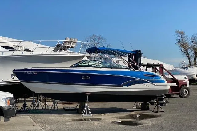 Slide: The Image of 2016 Formula 290 Bowrider boat on stands in a marina, blue and white design. - 13