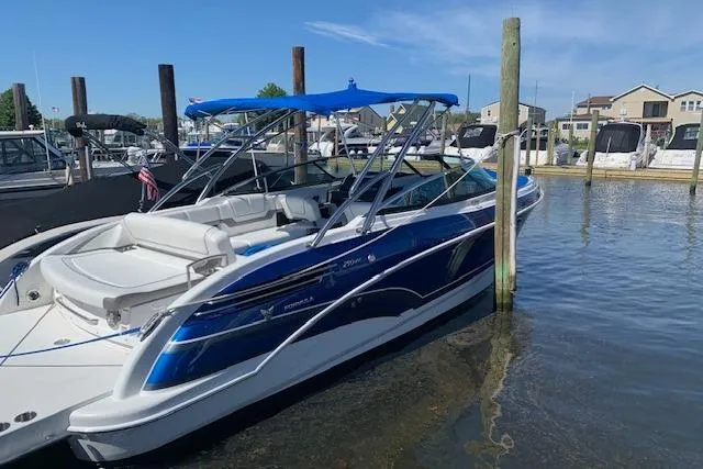Slide: The Image of 2016 Formula 290 Bowrider boat docked in marina with blue canopy. - 2