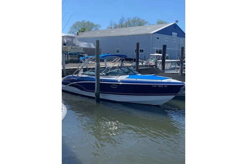 Slide: The Image of 2016 Formula 290 Bowrider boat docked at marina, blue and white design. - 3