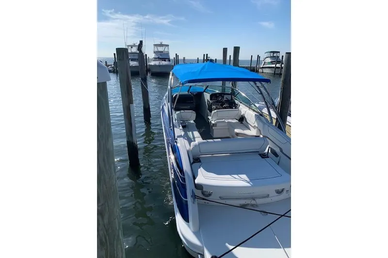 Slide: The Image of 2016 Formula 290 Bowrider with blue canopy docked at marina under clear sky. - 7