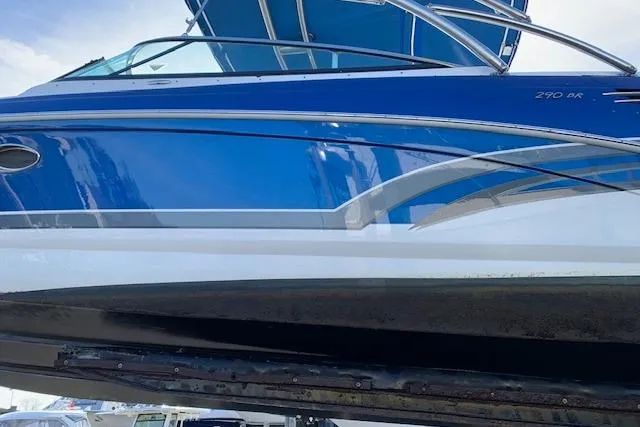 Slide: The Image of 2016 Formula 290 Bowrider boat with sleek blue and white design, docked outdoors. - 9