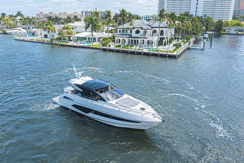 Slide: The Image of 2021 Sunseeker Predator 60 EVO yacht cruising near luxury waterfront homes. - 11