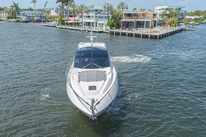 Slide: The Image of Luxury Sunseeker Predator 60 EVO yacht cruising near waterfront homes, 2021 model. - 12