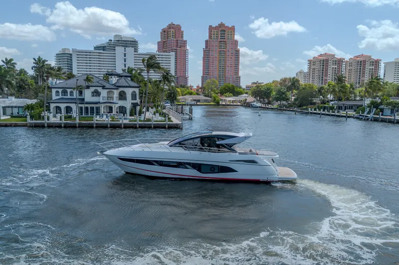 Slide: The Image of 2021 Sunseeker Predator 60 EVO yacht cruising near waterfront homes and city skyline. - 15