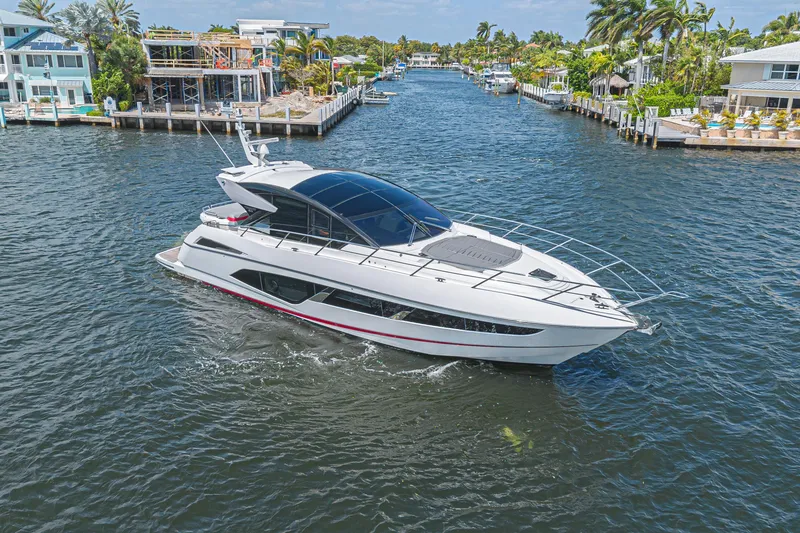 Slide: The Image of 2021 Sunseeker Predator 60 EVO yacht cruising in a scenic canal setting. - 16