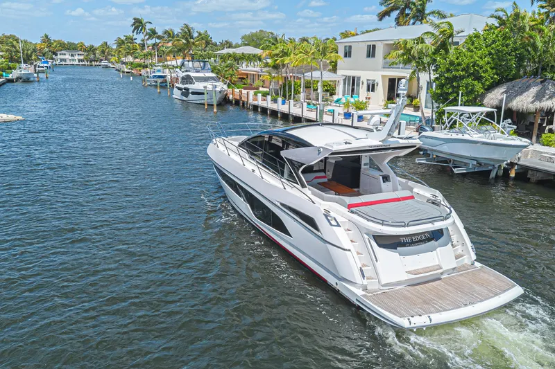 Slide: The Image of Sunseeker Predator 60 EVO 2021 yacht cruising in a scenic canal with palm trees. - 18
