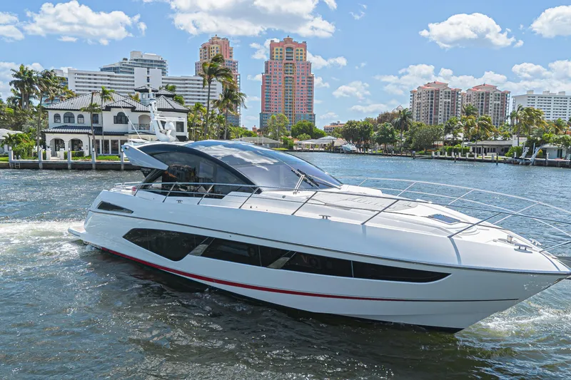 Slide: The Image of 2021 Sunseeker Predator 60 EVO yacht cruising near luxury waterfront homes. - 8