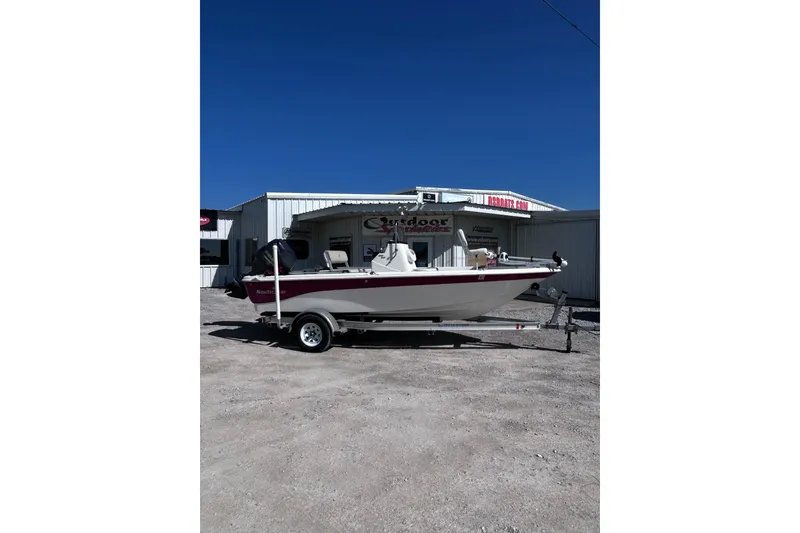 The Image of 2016 NauticStar 1810 NauticBay boat on trailer, parked outside a dealership. - 1