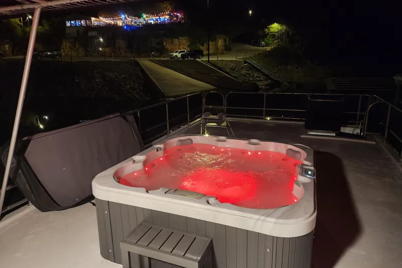 Slide: The Image of Rooftop hot tub with red lights on a Sharpe 85 houseboat at night. - 10
