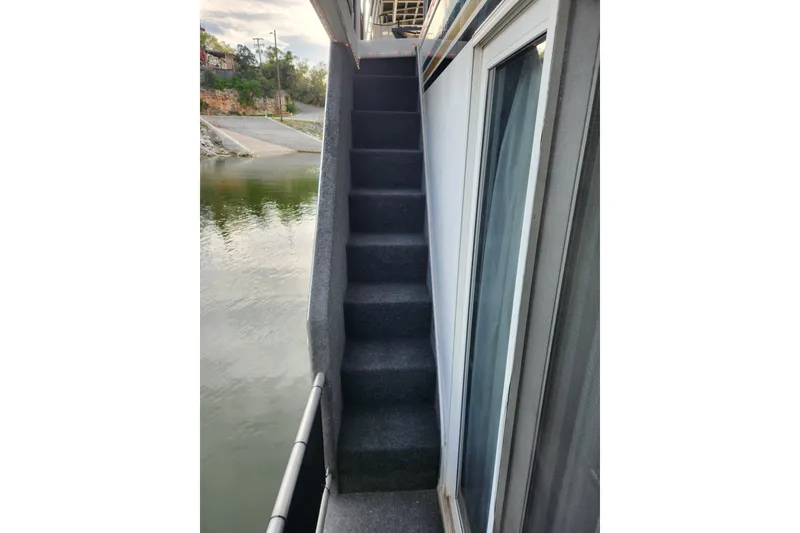 Slide: The Image of Narrow carpeted stairs on a 2000 Sharpe 85 houseboat by the water. - 11