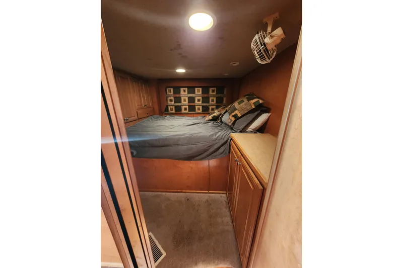 Slide: The Image of Compact bedroom in a 2000 Sharpe 85 houseboat with cozy bedding and wooden cabinetry. - 25