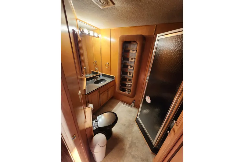 Slide: The Image of Compact bathroom in a 2000 Sharpe 85 model, featuring a shower, sink, and toilet. - 26