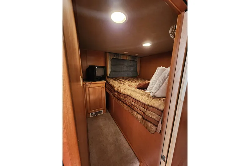 Slide: The Image of Cozy bedroom in 2000 Sharpe 85 houseboat with bed, pillows, and small TV. - 29