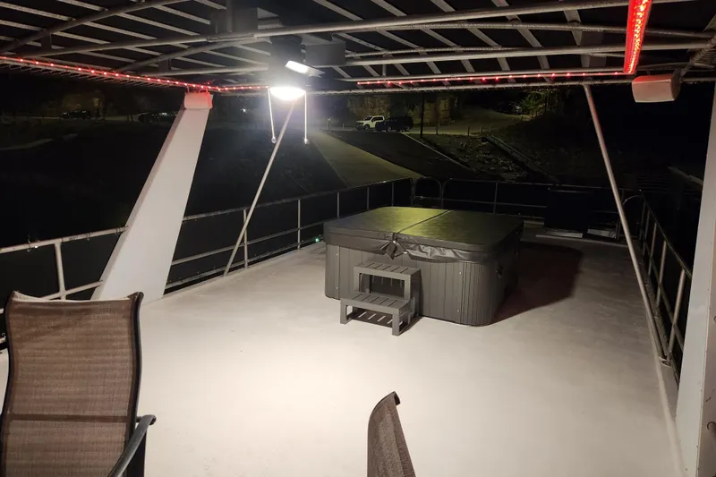Slide: The Image of Rooftop deck with hot tub on 2000 Sharpe 85 houseboat at night. - 8