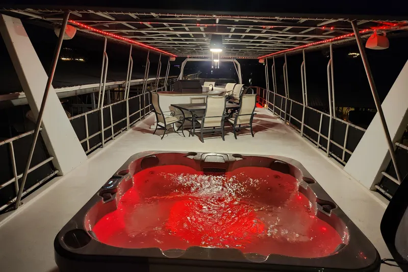 Slide: The Image of Luxurious houseboat deck with hot tub and dining area, illuminated by red lights. - 9