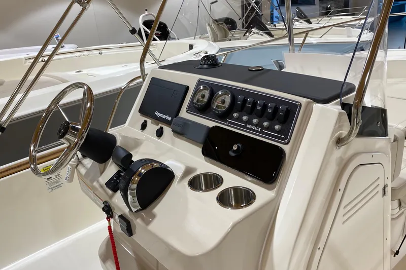 Slide: The Image of 2022 Boston Whaler 210 Montauk boat console with steering wheel and control panel. - 3
