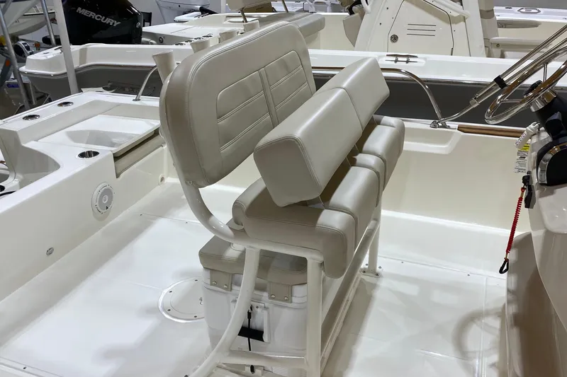 Slide: The Image of 2022 Boston Whaler 210 Montauk boat interior with cushioned seating and steering console. - 4