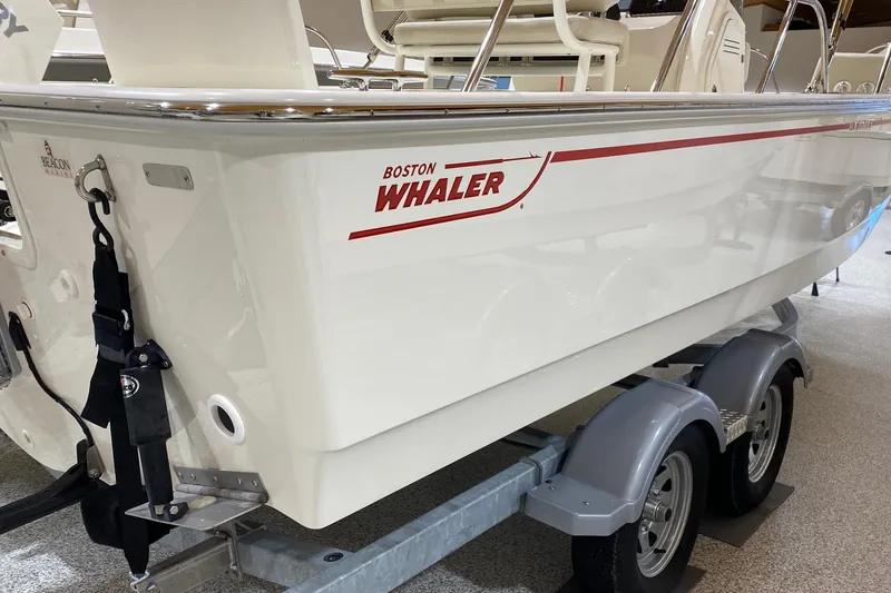 Slide: The Image of 2022 Boston Whaler 210 Montauk boat on trailer, showcasing sleek design and branding. - 6