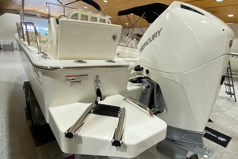 Slide: The Image of 2022 Boston Whaler 210 Montauk boat with Mercury engine, displayed indoors. - 7