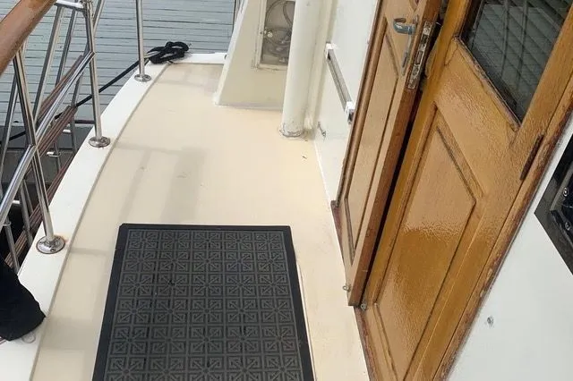 Slide: The Image of 1985 Gulfstar MK2 boat deck with wooden door and rubber mat. - 1