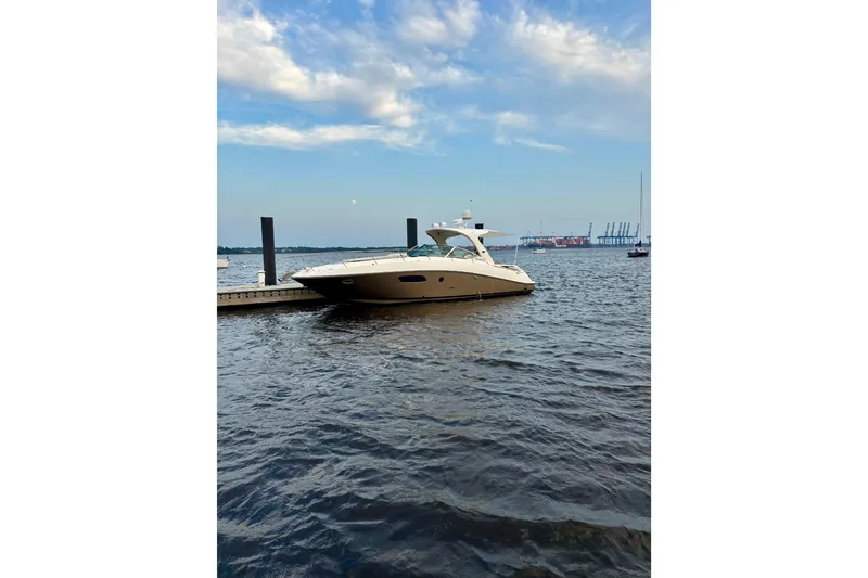 Slide: The Image of 2009 Sea Ray Sundancer 350 yacht docked on a calm, scenic waterfront. - 7