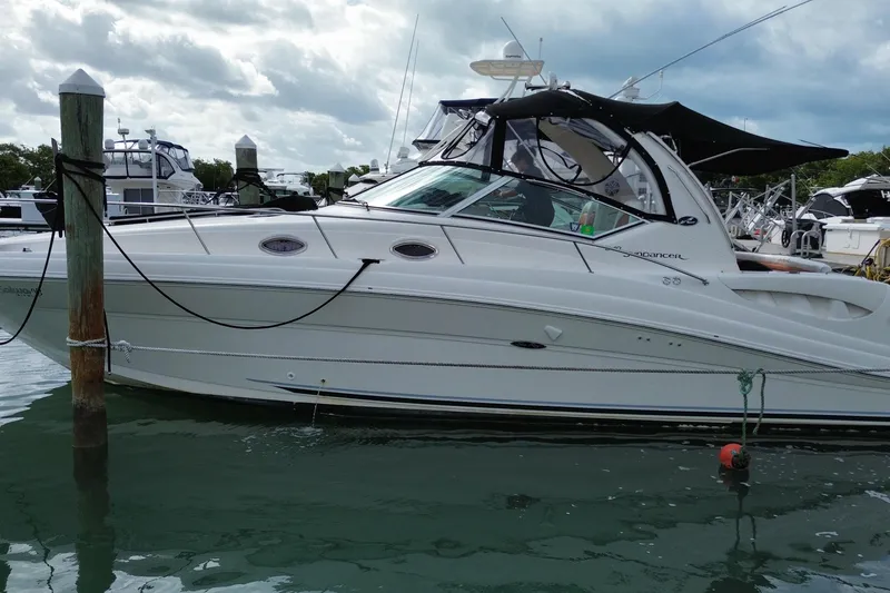 Slide: The Image of 2004 Sea Ray 340 Sundancer yacht docked in a marina under cloudy skies. - 12
