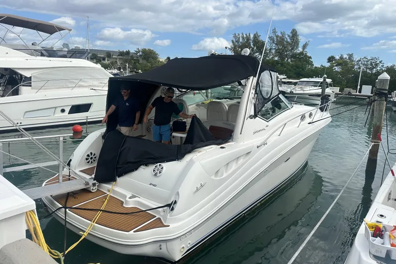 Slide: The Image of 2004 Sea Ray 340 Sundancer docked at marina with two people onboard. - 14